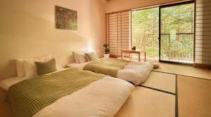 two beds in a room with a window at 來Lai 北軽井沢Resort Villa 158 in Tsumagoi