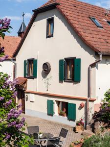 ein weißes Haus mit grünen Fensterläden und einem Innenhof in der Unterkunft Gîte Sylvaner sur la route des vins in Kintzheim