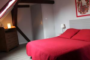 ein Schlafzimmer mit einem roten Bett und einer Kommode in der Unterkunft Gîte Sylvaner sur la route des vins in Kintzheim