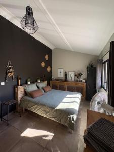 a bedroom with a large bed and a black wall at Pigeonnier des Banons in Puimoisson +70 photos