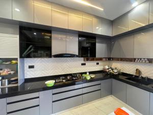 a kitchen with white cabinets and black counter tops at NTH Villa in Udaipur