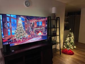 un soggiorno con una televisione a schermo piatto con alberi di Natale di Northern Lights Getaway! a North Pole