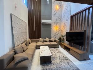 a living room with a couch and a flat screen tv at NTH Villa in Udaipur