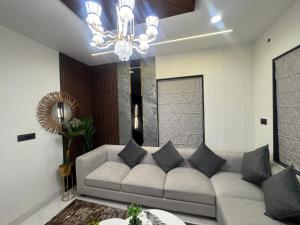 a living room with a couch and a chandelier at NTH Villa in Udaipur