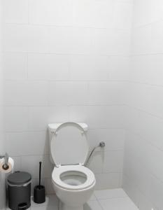 a white bathroom with a toilet and a trash can at Golden Day Bedouin Camp in Wadi Rum