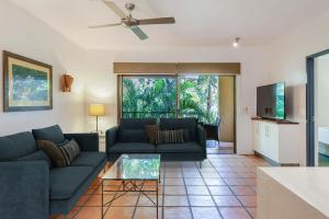 2BR Ground-Floor Gem, Walk to Everything, 2 Pools في ميناء دوغلاس: غرفة معيشة بها أريكة وطاولة