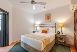 2BR Ground-Floor Gem, Walk to Everything, 2 Pools في ميناء دوغلاس: غرفة نوم بسرير وموقف ليلي مع مصباح +7 صور