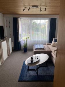 ein Wohnzimmer mit Sofa und Tisch in der Unterkunft Dachwohnung in Niederuzwil