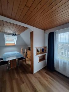 ein Esszimmer mit einem Tisch und einem Fenster in der Unterkunft Dachwohnung in Niederuzwil