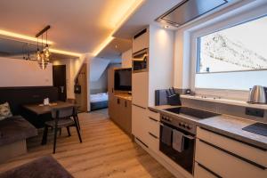 een keuken en een woonkamer met een groot raam bij Place2be in Ischgl