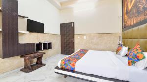 a bedroom with a bed and a tv on a wall at Sumanglam in Dehradun