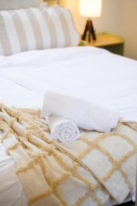 Una cama con mantas blancas y almohadas. en Modern Riverwood Home with Parking & Easy Access, en Riverwood 10 fotos más