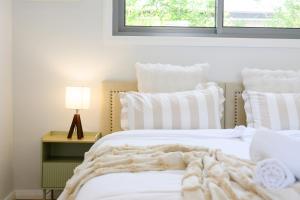 Una cama blanca con una manta encima. en Modern Riverwood Home with Parking & Easy Access, en Riverwood