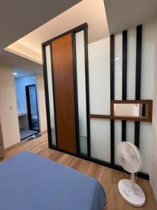Schlafzimmer mit einem Bett, einem Ventilator und einem Schrank in der Unterkunft 東印象 in Hsin-kuang + 4 Fotos