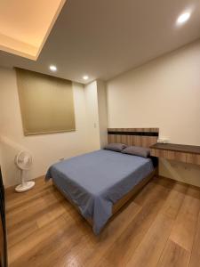 ein Schlafzimmer mit einem großen Bett und einem Ventilator in der Unterkunft 東印象 in Hsin-kuang