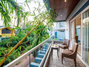 a balcony with two chairs and a table at Villa Vana by DanCenter in Arpora