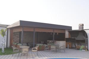 a patio with tables and chairs and a grill at Davos Hotel in Pʼarakʼar