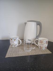 a coffee pot and two cups on a table at Private Haven Escape in Pereybere