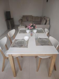 a white dining room table with white chairs and flowers at Private Haven Escape in Pereybere