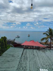 a dock with a red tent and boats in the water at Private Haven Escape in Pereybere