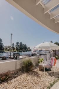 a patio with a chair and a view of a harbor at The Waterfront Apartment in Port Fairy