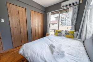 北谷町にあるKomachi Houseのベッドとタオル2枚のある寝室