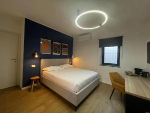 a bedroom with a white bed and a desk and a light at KJ guesthouse in Appiano Gentile