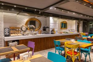 a restaurant with wooden tables and colorful chairs at Tulip City Hotel & SPA in Istanbul