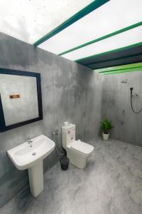 a bathroom with a sink and a toilet at EMERALD HAVEN SAFARI Cottages in Udawalawe