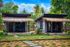 a small house with a thatched roof at EMERALD HAVEN SAFARI Cottages in Udawalawe