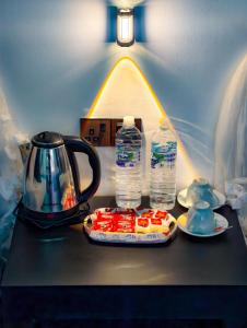 a table with a tea kettle and two bottles of water at EMERALD HAVEN SAFARI Cottages in Udawalawe