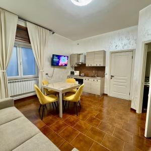 ein Wohnzimmer mit Tisch und Stühlen und eine Küche in der Unterkunft Suite sogni di lago Lecco, Como in Malgrate