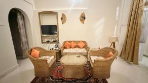 古瓦哈提Baruah Bhavan Homestay的客厅配有藤椅和镜子