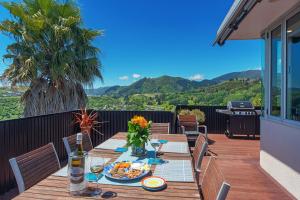 纳尔逊Aporo Nelson Holiday Home的露台上摆放着食物的木桌，视野开阔