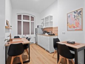 Neueröffnung - Haus Ysenburg - Wohnungen in zentraler Lage في كاسيل: مطبخ مع طاولة وكراسي في الغرفة