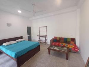 a bedroom with a bed and a couch and a table at Villa diamond nest in Unawatuna