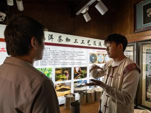 two men looking at a display in a museum at 丽江指云公馆Nakhi Cultural Experience在地体验民宿 in Lijiang
