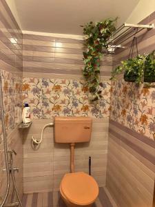a bathroom with a toilet and flowers on the wall at SurfN Tides by BHoomiKA in Kappil +27 photos