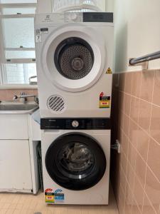 Una lavadora y secadora en una cocina al lado de un fregadero. en Sunset Sisters - Villa Lola & Villa Frankie, en Forster
