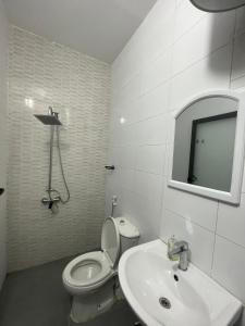 Un baño con inodoro, lavabo y espejo. en Les merveilles, en Pikine