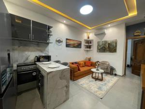 Una cocina y una sala de estar con un sofá. en Les merveilles, en Pikine 1 foto más