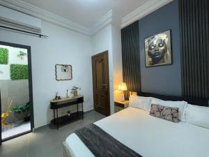 Un dormitorio con una cama blanca grande y una ventana en Les merveilles, en Pikine