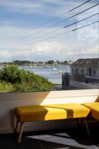 ein Fenster mit Blick auf das Wasser und die Boote in der Unterkunft Jolie maison neuve PMR au port de l'Aberwrac'h in Landéda