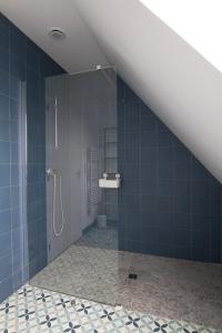 ein Bad mit einer Dusche und blauen Fliesen in der Unterkunft Jolie maison neuve PMR au port de l'Aberwrac'h in Landéda