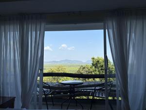 a balcony with a table and a view of a field at BaanPhutawanLanta in Ban Mo Nae