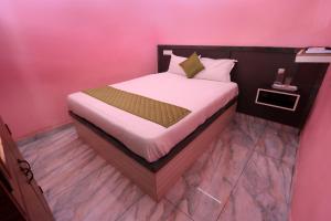 Arun Auro Residency في Kuilapayam: سرير في غرفة بجدار وردي +65 صورة