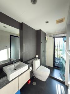 ein Badezimmer mit weißer Toilette und Waschbecken in der Unterkunft 6th Avenue 2 bedroom in Surin Beach