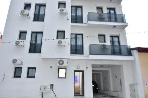 a white building with windows and a balcony at Sunrise Rooms in Bucharest