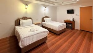 a hotel room with two beds and a television at HUG PHIPHI Resort in Phi Phi Islands
