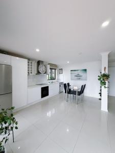 eine weiße Küche mit einem Tisch und Stühlen in der Unterkunft Refined Surfers Paradise Escape with Captivating Night City Views in Gold Coast